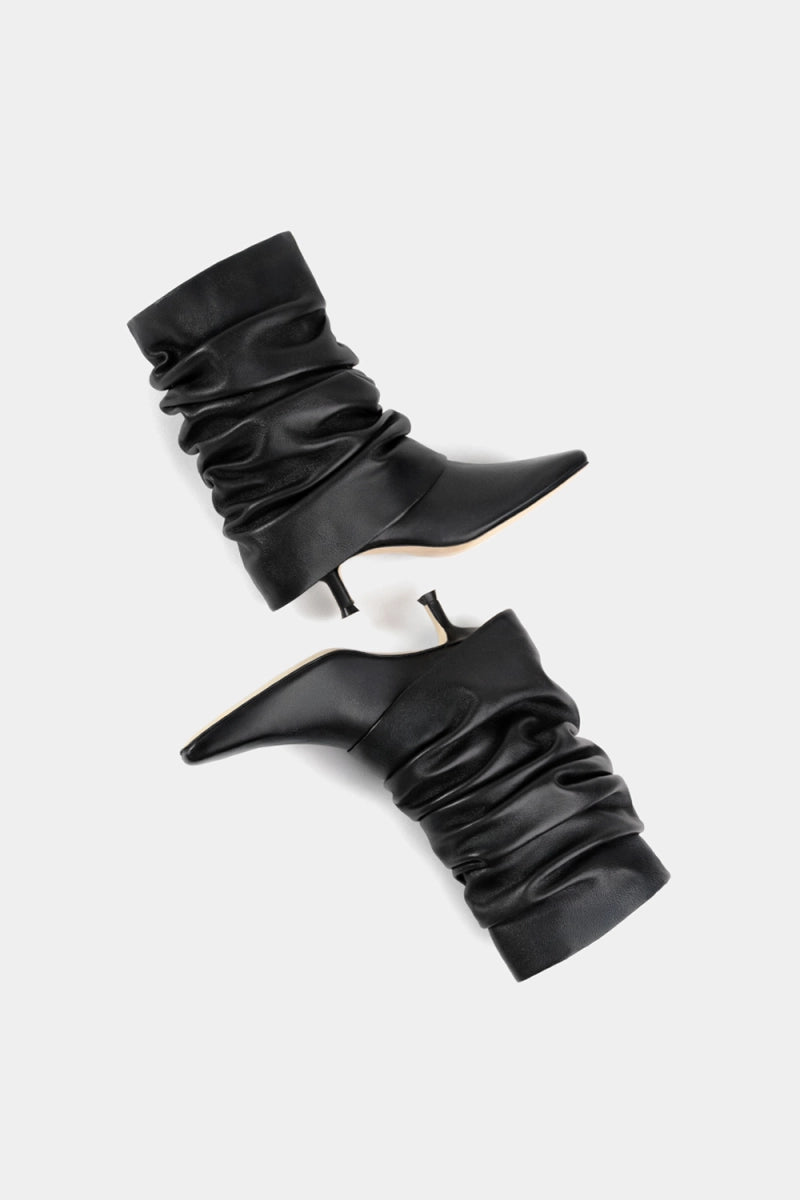 Bota negra suave de tacto cuero, caña abullonada y tacón fino de 4 cm