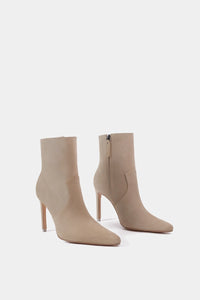 Bota casual beige con tacón de aguja, diseño ceñido al tobillo y apariencia elegante de ante