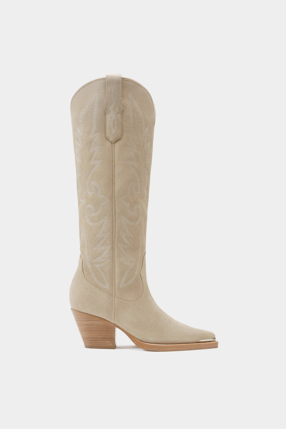 Vista lateral de bota western elegante en gamuza beige con bordados blancos y punta metálica.