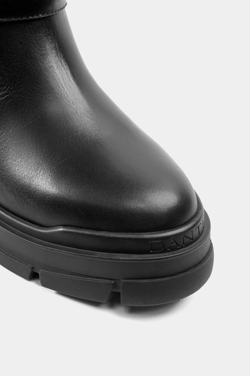 Bota negra contemporánea con diseño minimalista, hebilla superior y suela gruesa de goma