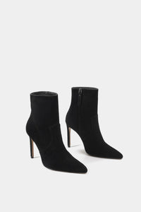 Botín femenino de tacón delgado y alto estilo sock boot en tejido negro con puntera puntiaguda