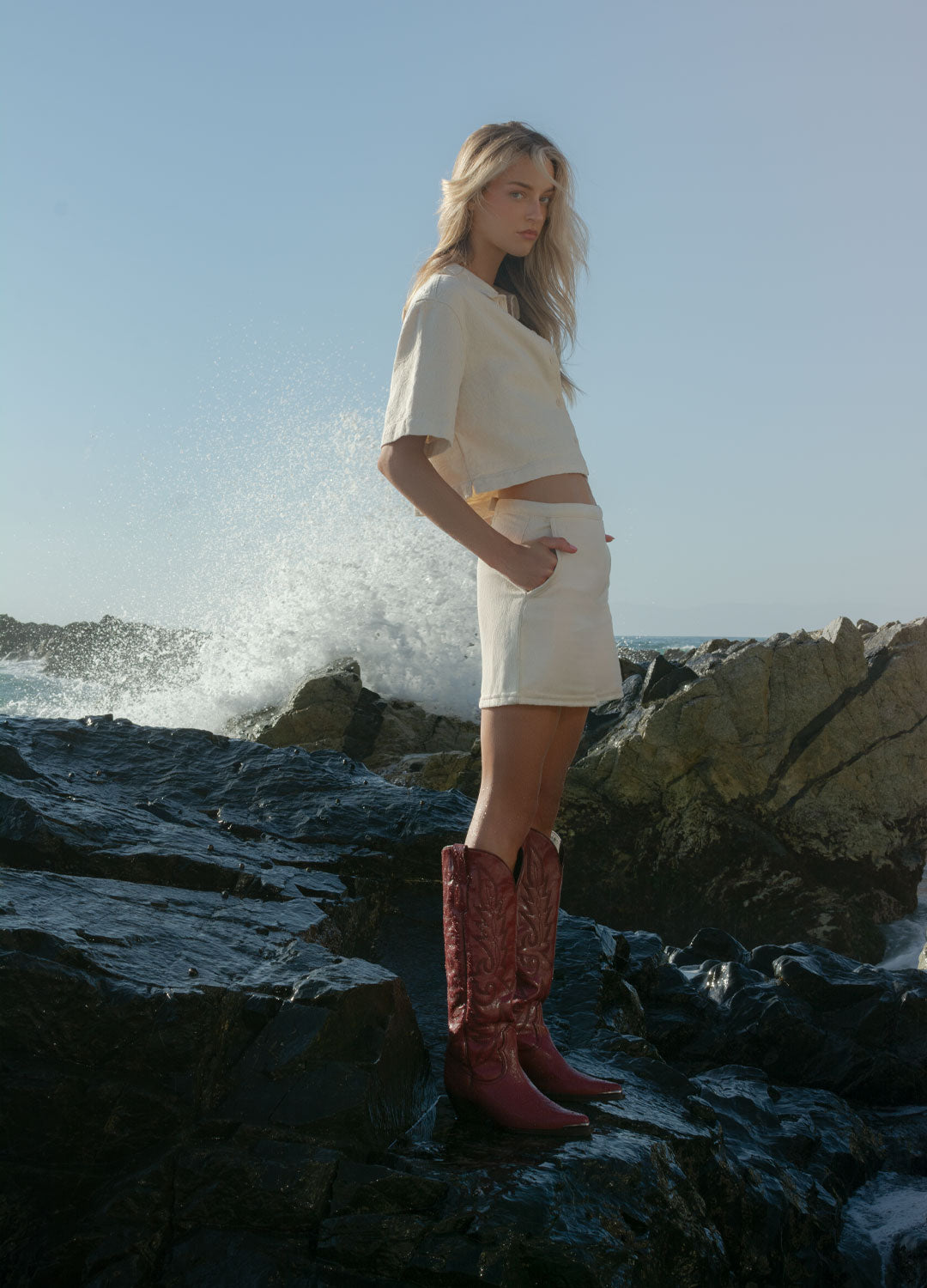 chica en la playa con botas estilo miu miu rojas con bordados western hechas en leon guanajuato